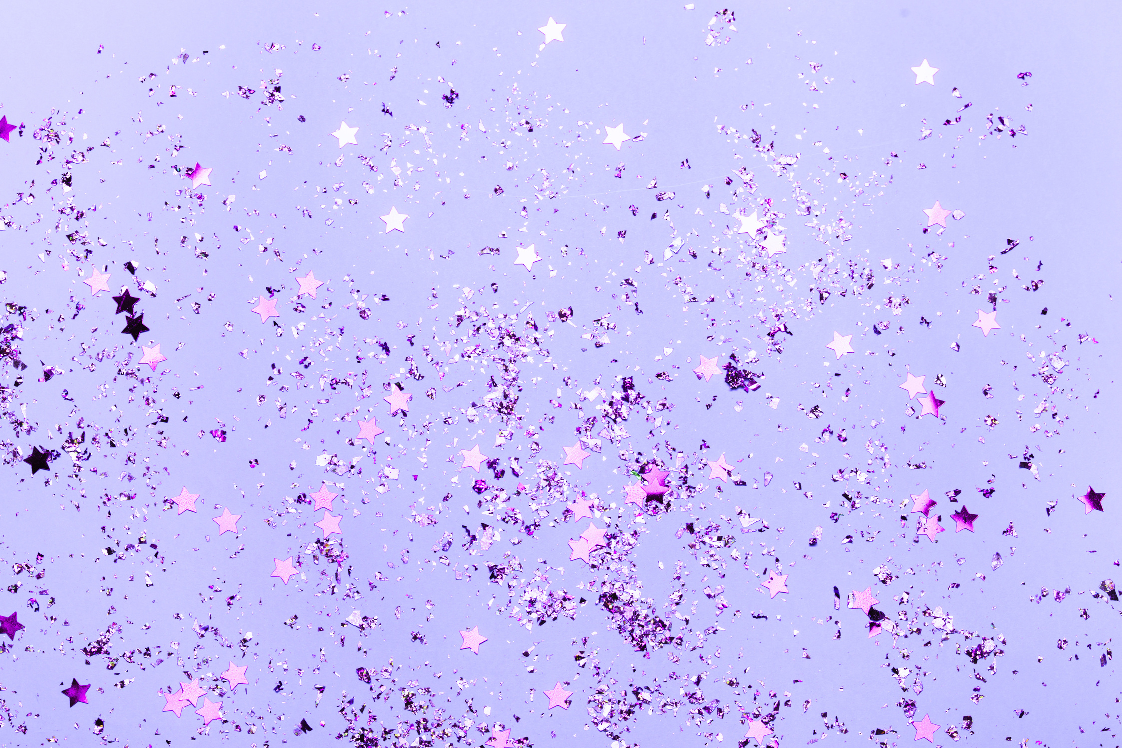 Violet confetti and violet stars and sparkles on violet background.